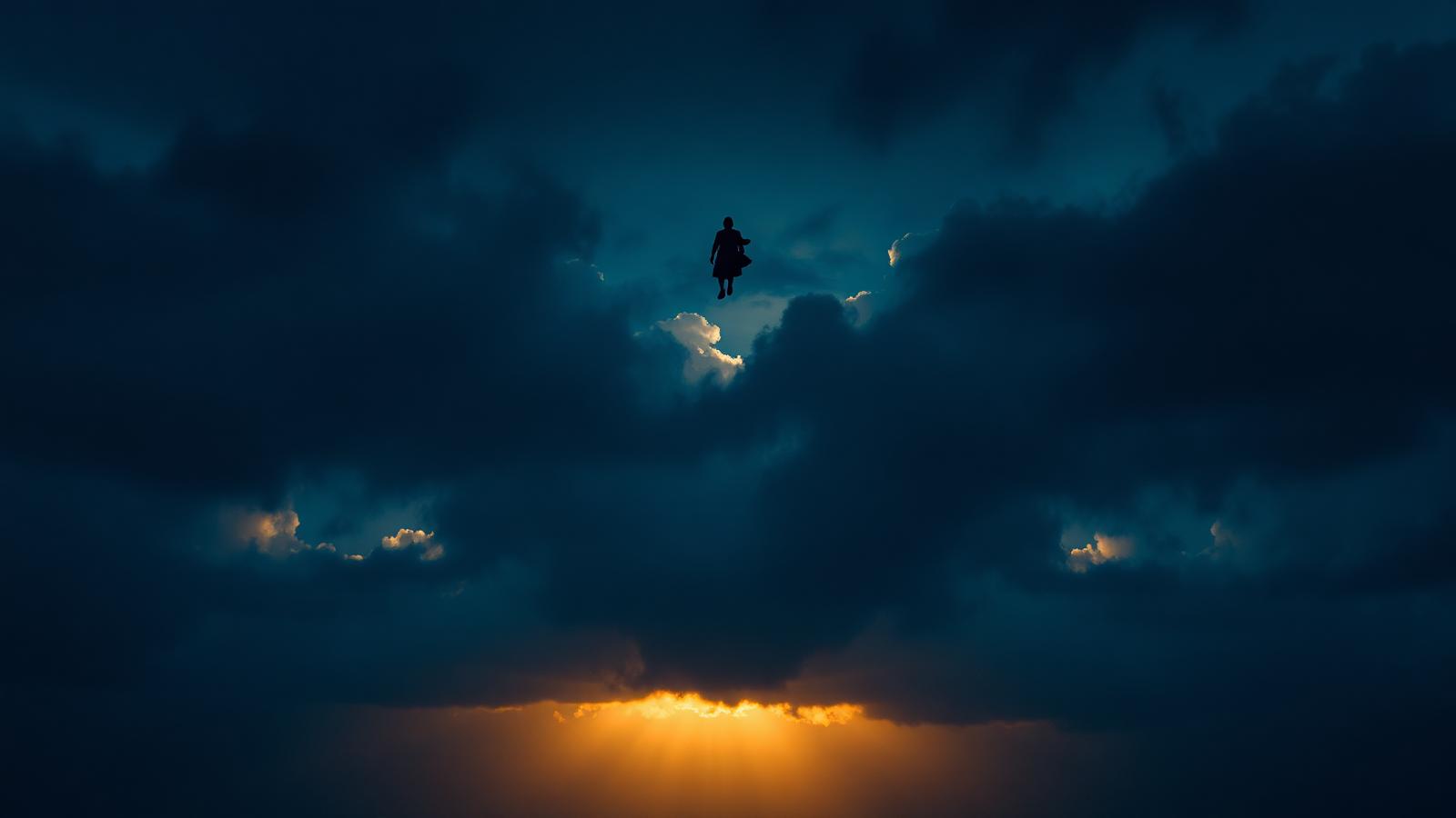 Silueta cayendo entre nubes oscuras hacia una luz dorada