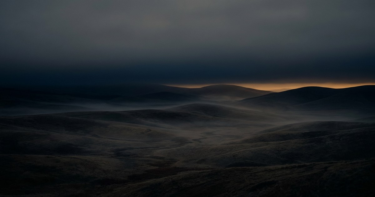 Un paisaje vasto y sereno bajo un cielo gris de atardecer, representando el descanso interior y el silencio de la desolación.